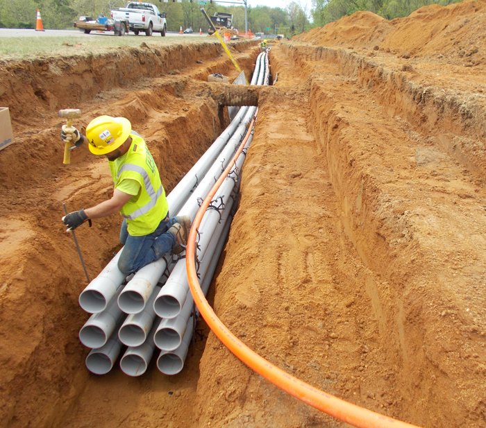 APG Electrical Distribution System conduit in trench with worker